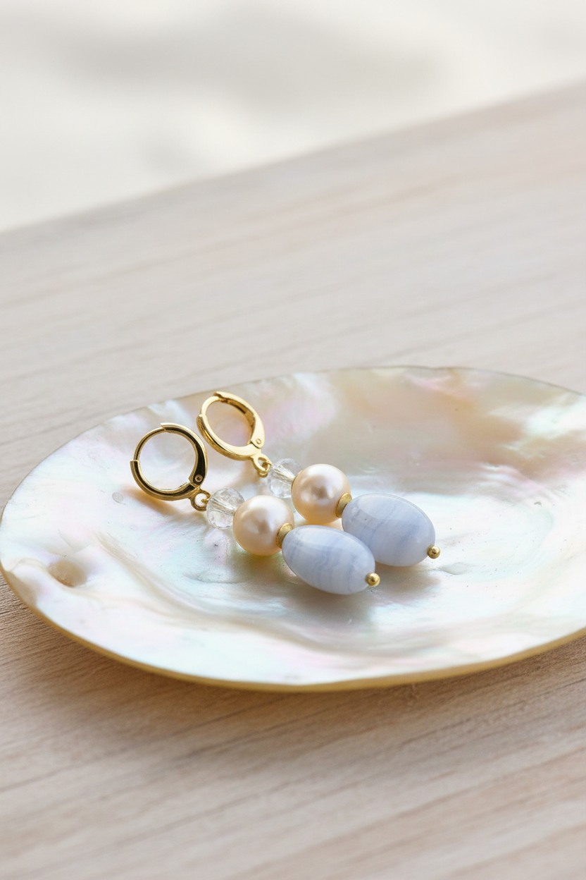 Brincos Duna Azul (Kék) da Körössy — semijoia banhada a ouro 18k com ágata blue lace, pérola e cristal austríaco, feitos à mão.