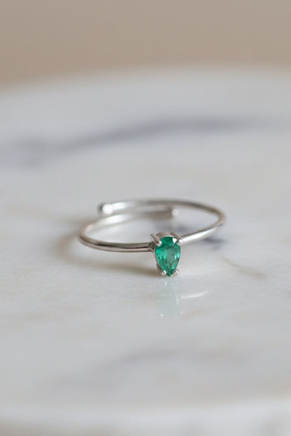 Anel KÖRÖSSY em prata 925 com esmeralda em formato de gota, design ajustável.