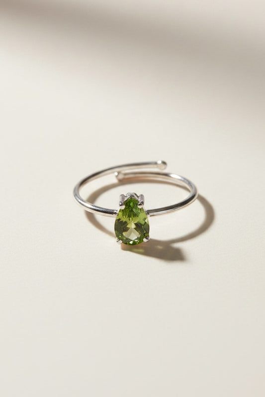 Anel KÖRÖSSY em prata 925 com peridoto verde luminoso lapidado em gota, tamanho ajustável.