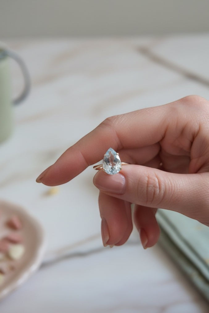 Anel KÖRÖSSY em prata 925 com topázio azul lapidado em gota, com design delicado e luminoso.