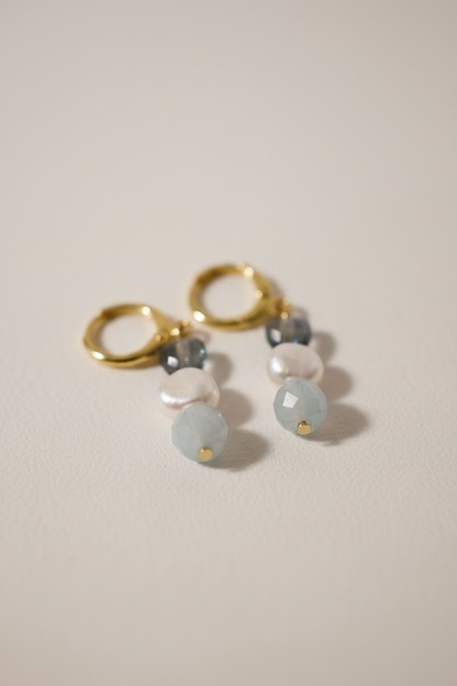 Brincos Duna Sopro (Lehelet) da Körössy — semijoia banhada a ouro 18k com água-marinha, pérola e cristal austríaco, feitos à mão.