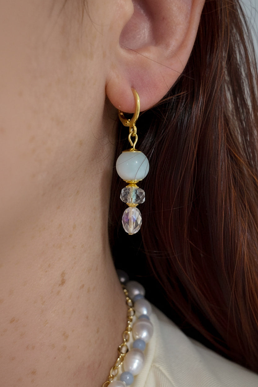 Brincos Duna Luz (Fény) da Körössy — semijoia banhada a ouro 18k com água-marinha e cristal austríaco, feitos à mão.