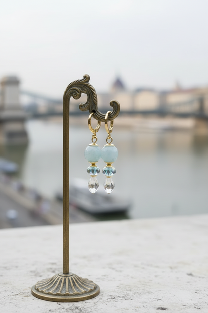 Brincos Duna Luz (Fény) da Körössy — semijoia banhada a ouro 18k com água-marinha e cristal austríaco, feitos à mão.